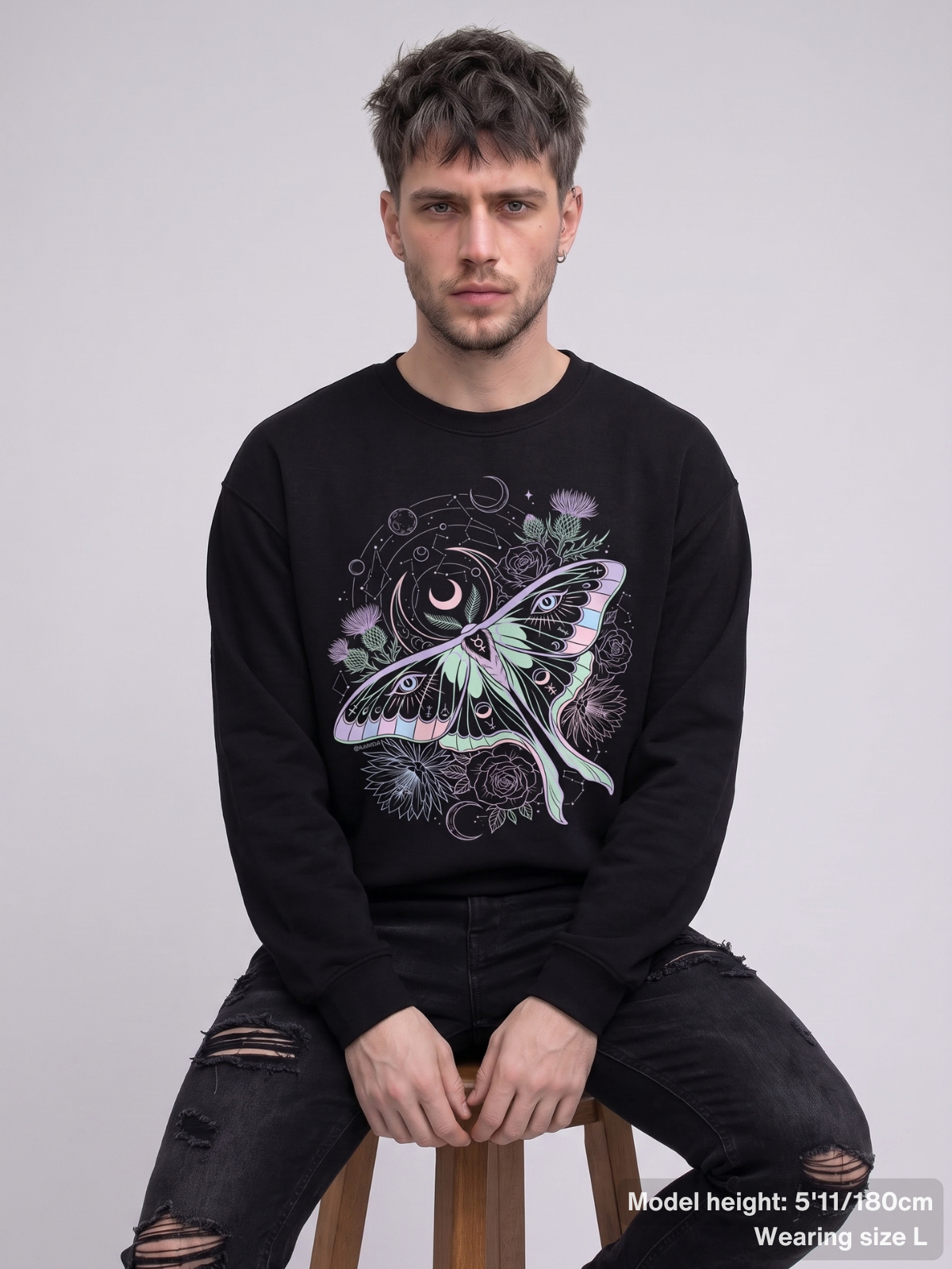 Male model wearing the KAMIOJI celestial luna moth graphic sweatshirt with moons, flowers and mystical eye details | Colour: Black