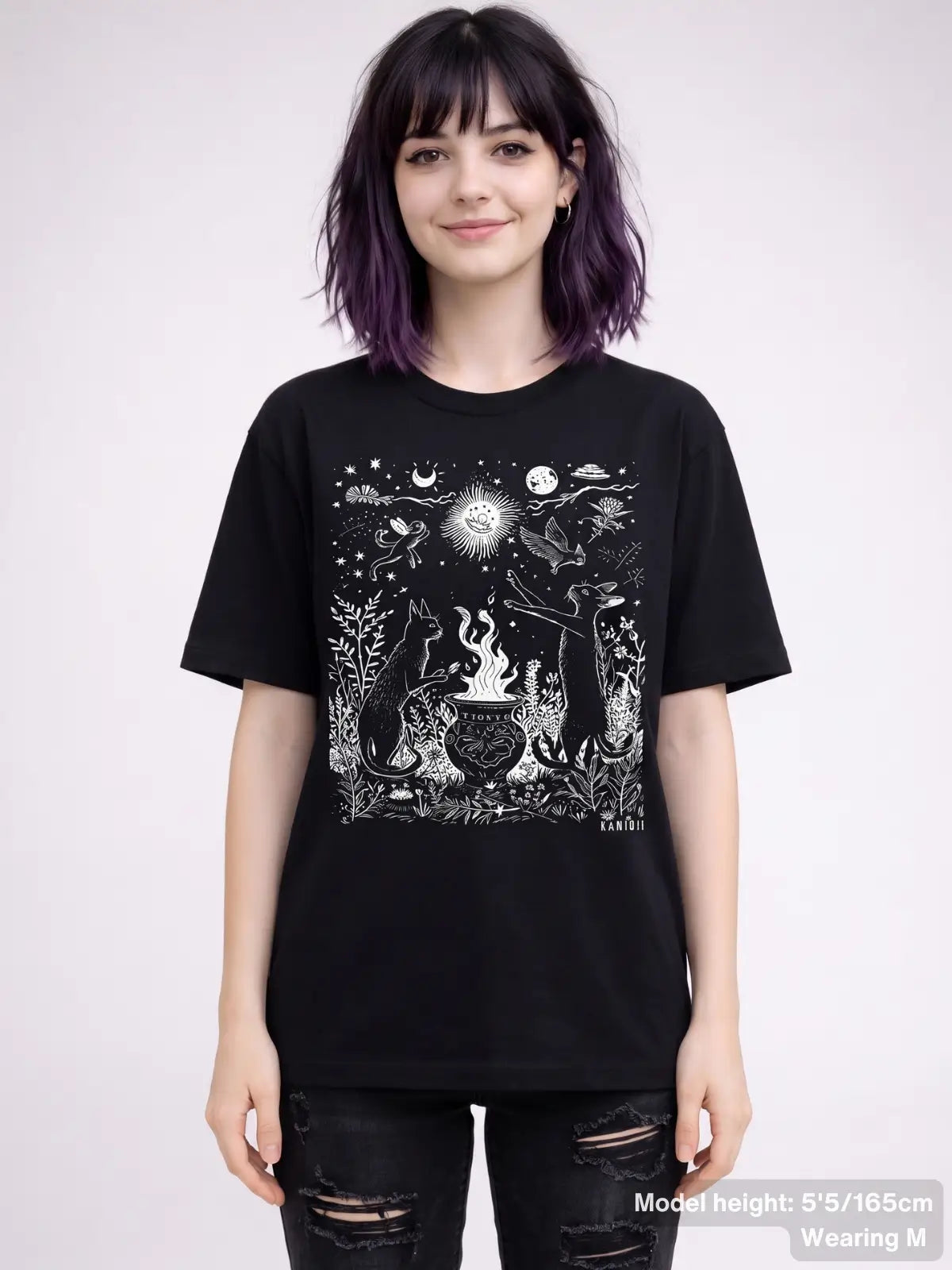 T shirt featuring a detailed celestial illustration of cats gathered around a cauldron, surrounded by stars, moons, plants, and animals. KAMIOJI. | Colour: Black