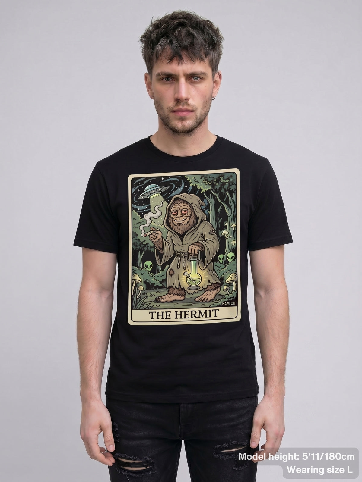 Graphic of a retuned tarot card featuring Bigfoot, small alien figures hidden in the forest, and a UFO in the sky.