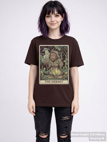 Funny cryptid streetwear shirt displaying a detailed illustration of a smoking Bigfoot as 'The Hermit' with psychedelic forest details.
