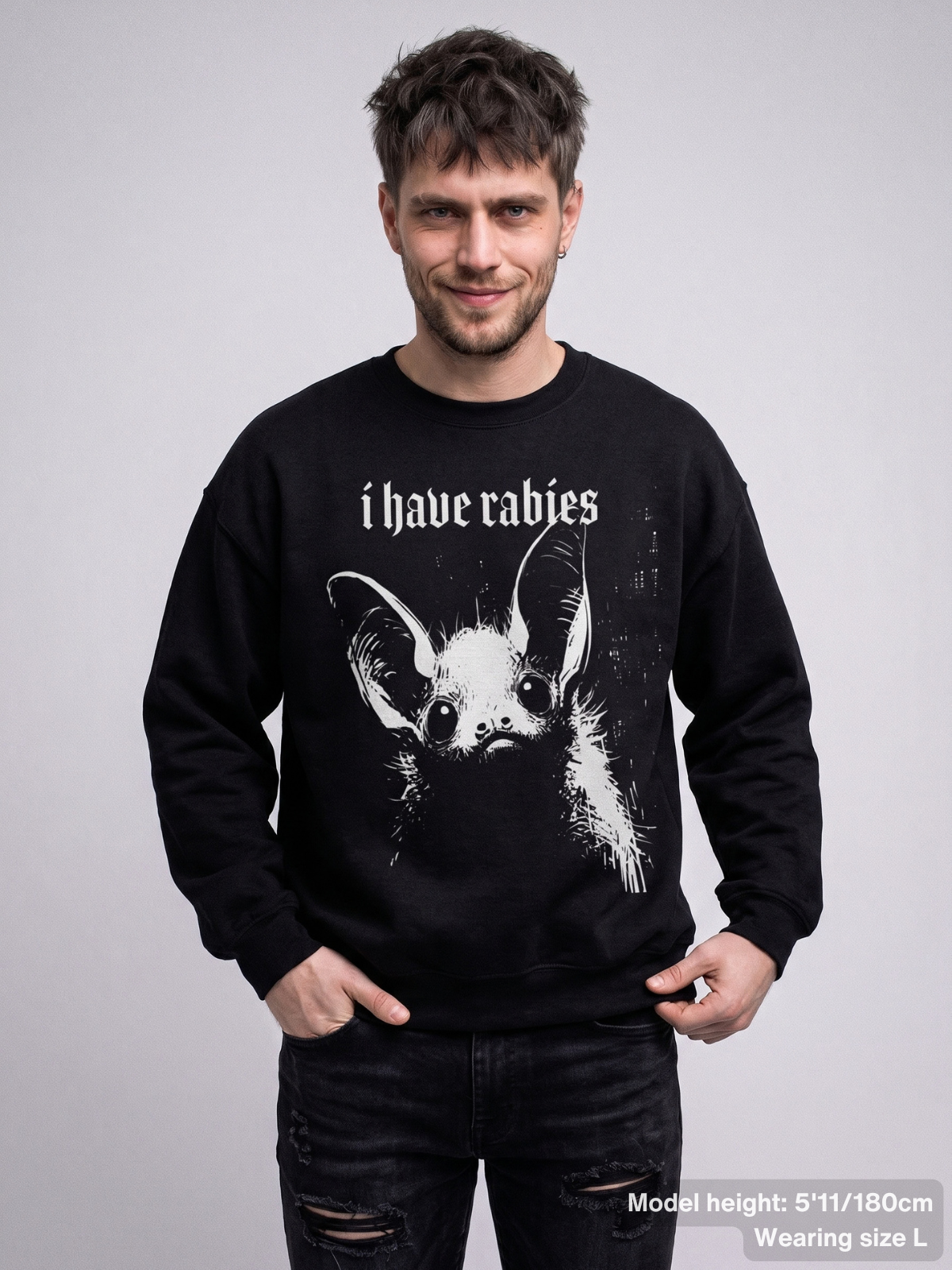 Male model wearing the KAMIOJI I Have Rabies graphic sweatshirt featuring a distressed gothic bat design | Colour: Black