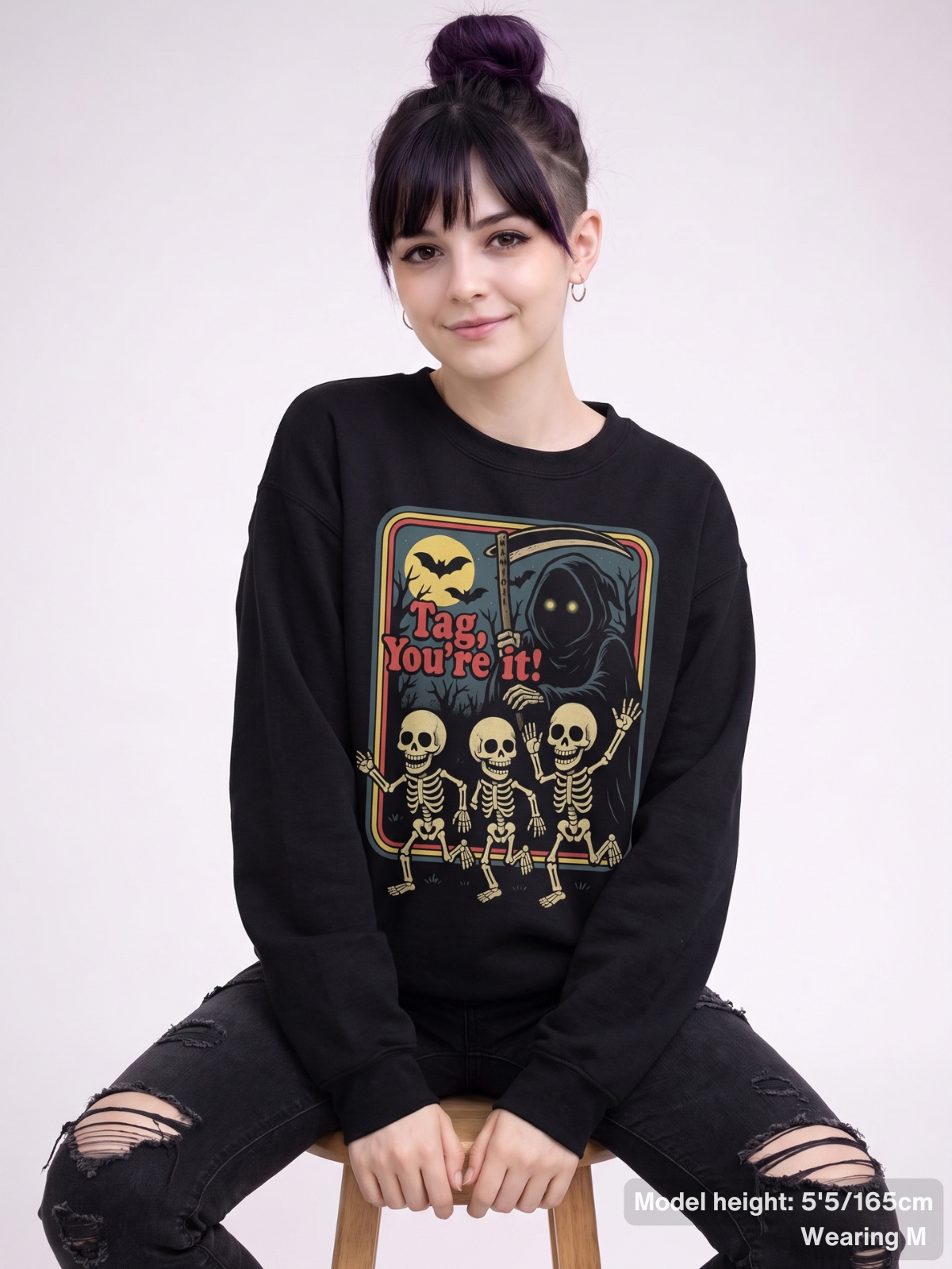 Female model wearing the KAMIOJI Tag You’re It skeleton Halloween graphic sweatshirt | Colour: Black