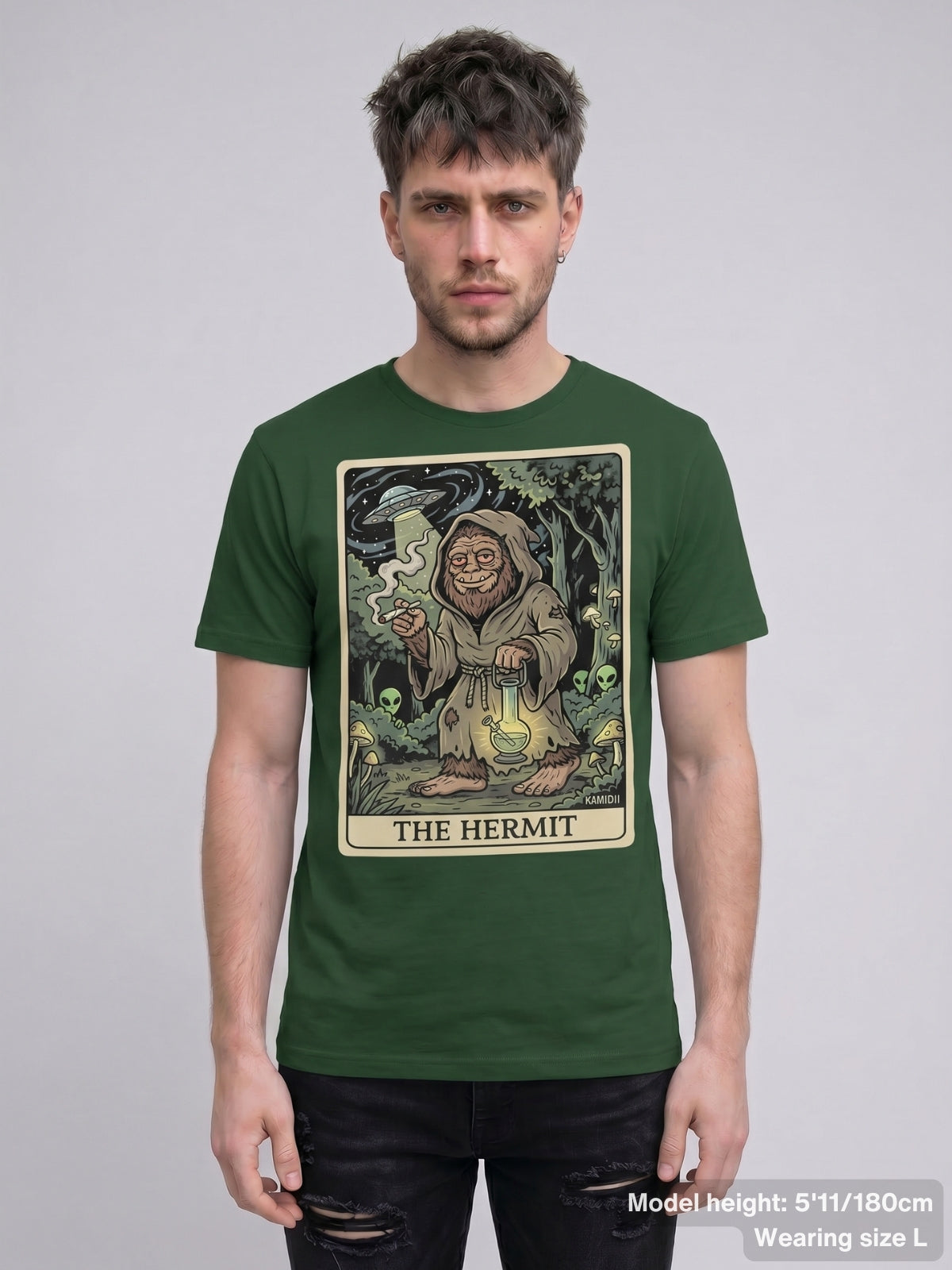 Graphic tee showcasing Bigfoot in a forest with hidden alien figures and a UFO, from 'The Hermit' tarot card.