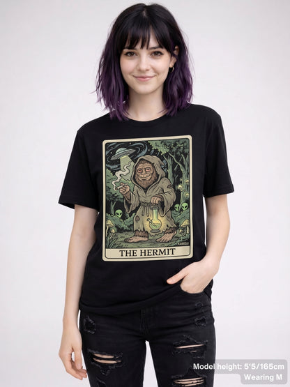 hooded Sasquatch figure holding a bong in place of a lantern on 'The Hermit' tarot card design.