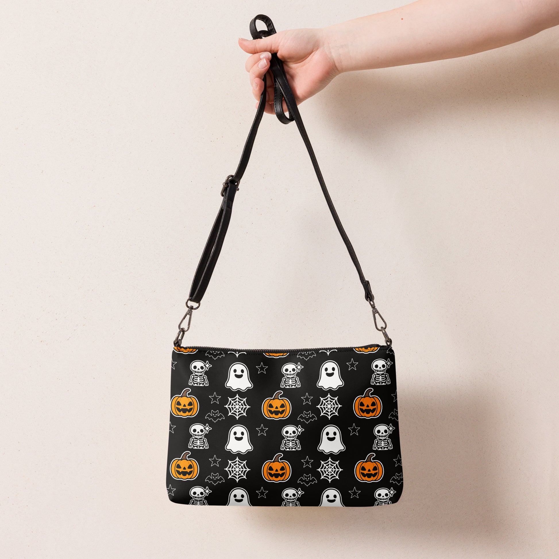 Halloween-themed crossbody bag with cartoon ghosts, pumpkins, webs, and skeletons on black