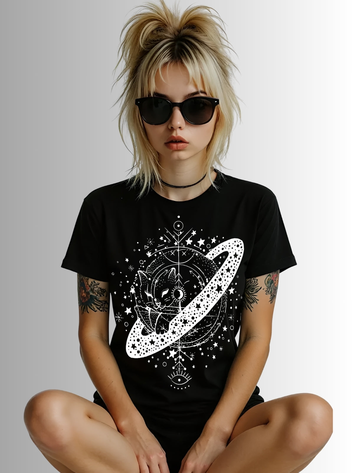 Gothic black tee with cosmic cat illustration resting on Saturn-like planet in detailed white linework