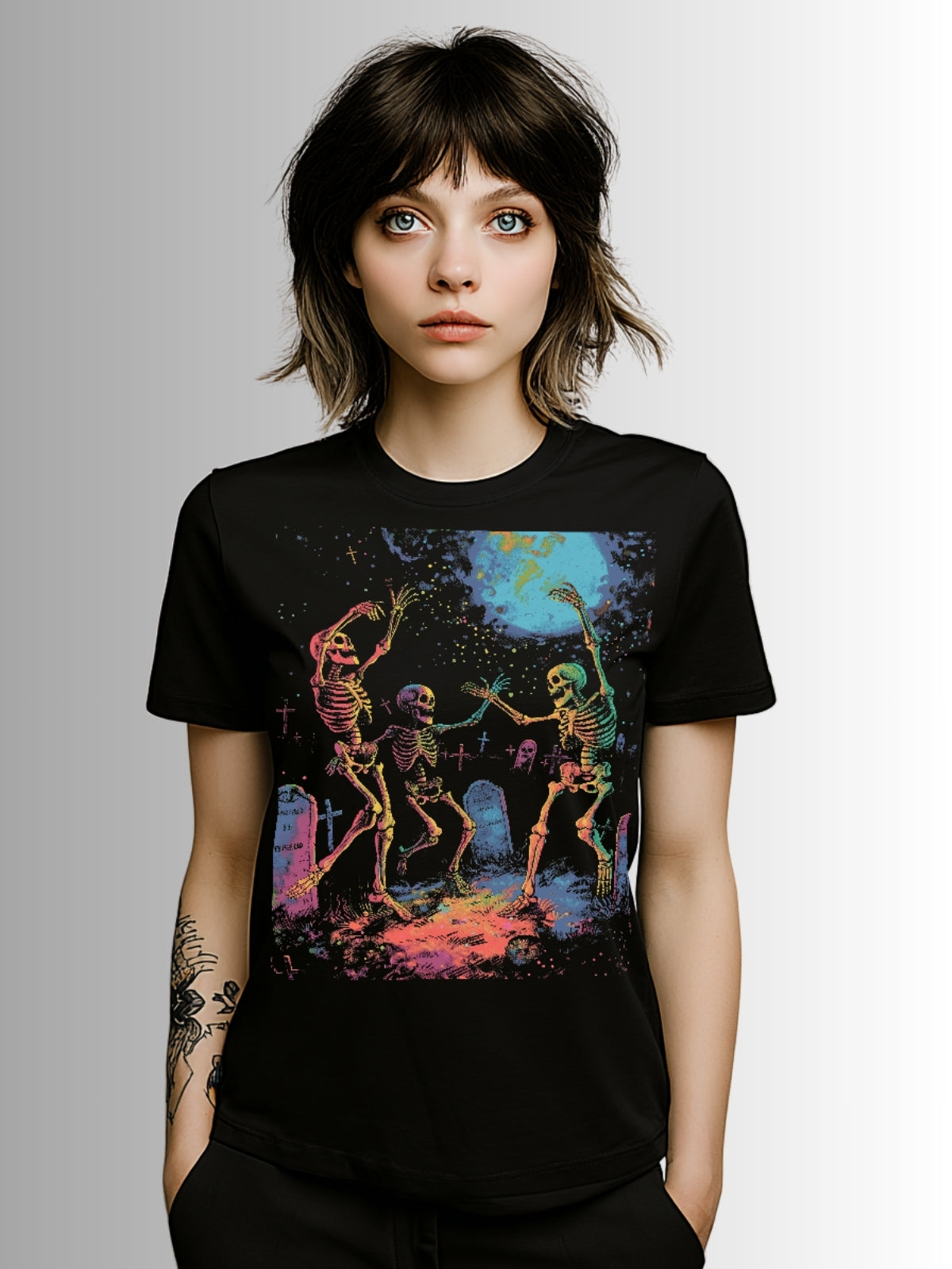 Alternative T-shirt featuring neon skeletons celebrating among gravestones at night