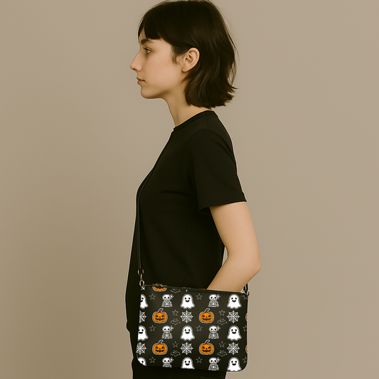 Black crossbody bag with cute ghost, pumpkin, skeleton, and spiderweb Halloween pattern