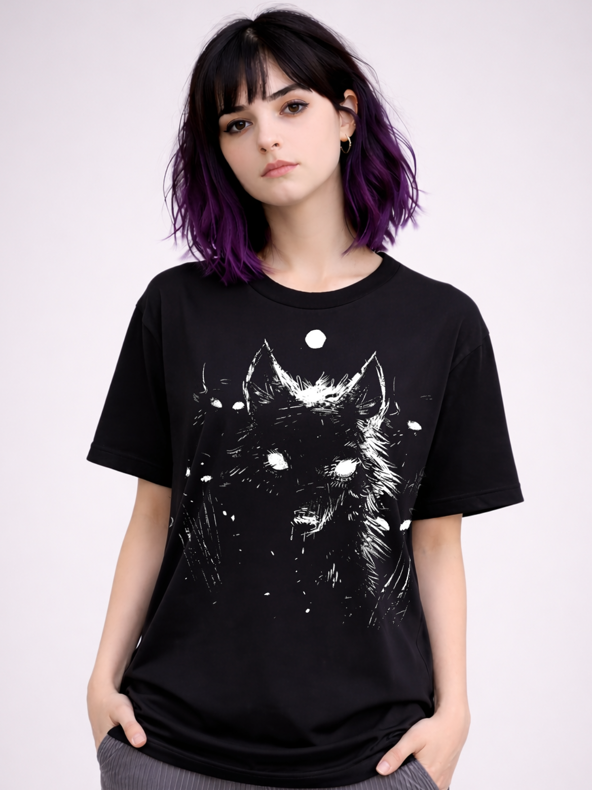 Black t shirt featuring a white wolf illustration with a small moon above its head, printed in a rough, high contrast line style on the front. The design is centered on the chest and photographed on a model against a neutral background.